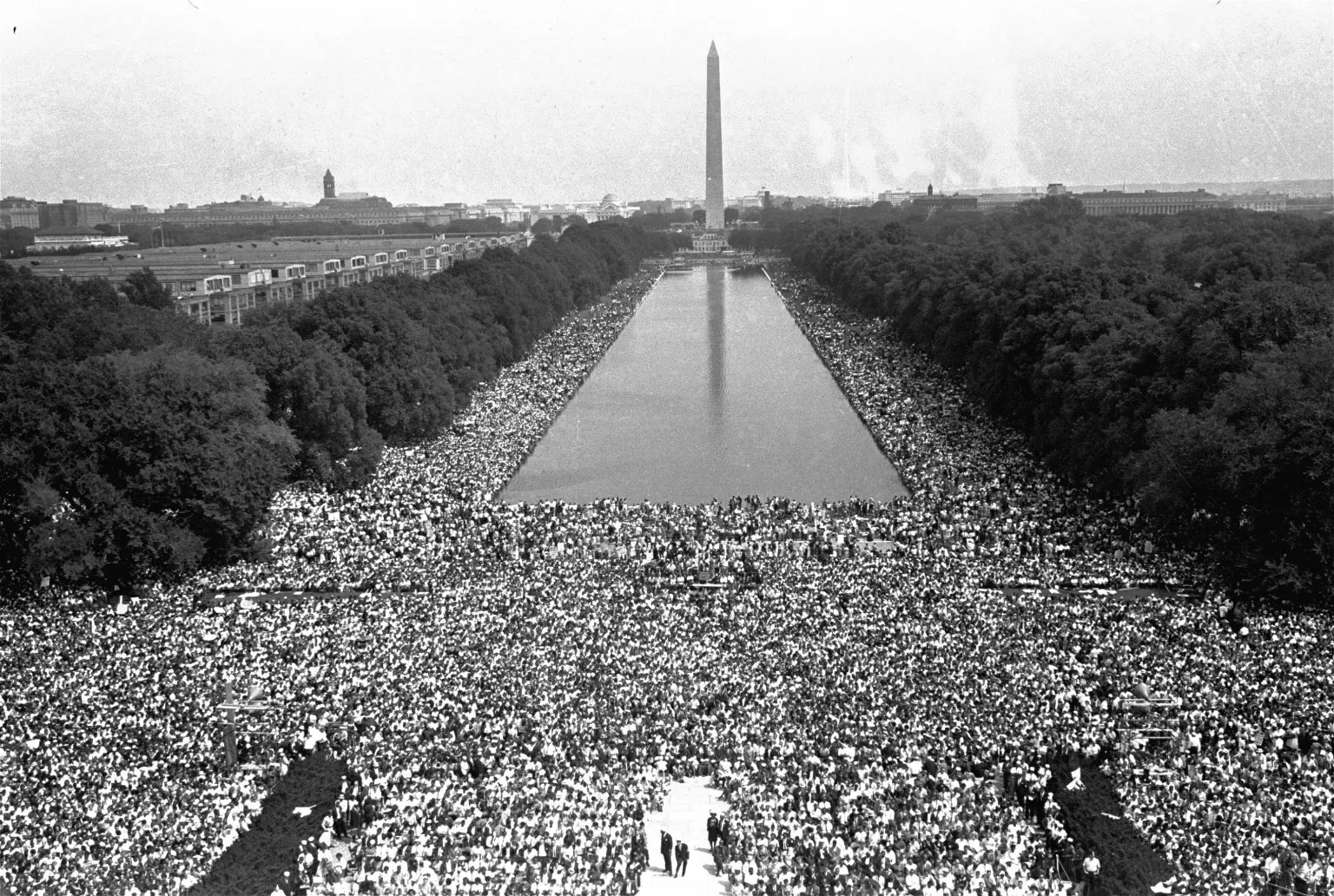 A large crowd of people gathered in front of the washington monument.